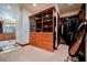 Large walk-in closet with custom cabinetry, glass display cases, and full-length mirror at 8280 Via Olivero Ave, Las Vegas, NV 89117