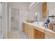 Bathroom featuring double sinks, cabinets, a large mirror, and a walk-in closet at 8426 Sluman Ct, Las Vegas, NV 89128