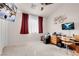 Spacious bedroom, showcasing two wall-mounted TVs, a ceiling fan, and built-in desk at 8426 Sluman Ct, Las Vegas, NV 89128