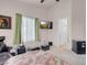 Bright bedroom featuring a ceiling fan, window, TV, and doorway leading to en-suite bathroom at 8426 Sluman Ct, Las Vegas, NV 89128