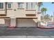 Tan two-story home with garage and palm trees in the background at 8426 Sluman Ct, Las Vegas, NV 89128