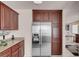 Kitchen featuring a stainless steel refrigerator, dark wood cabinetry, and ample counter space at 8426 Sluman Ct, Las Vegas, NV 89128