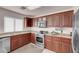 Cozy kitchen featuring wood cabinets, stainless steel appliances, and tiled flooring at 8426 Sluman Ct, Las Vegas, NV 89128