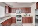 Modern kitchen featuring dark wood cabinetry, granite countertops, and stainless steel appliances at 8426 Sluman Ct, Las Vegas, NV 89128