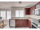 Modern kitchen featuring stainless steel appliances, dark wood cabinetry, and tiled floors at 8426 Sluman Ct, Las Vegas, NV 89128