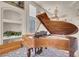 Bright living room featuring an ornate wood piano, large windows, and an upper-level landing at 8426 Sluman Ct, Las Vegas, NV 89128