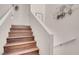 Staircase with wood steps and white bannister with contemporary artwork on the wall at 8426 Sluman Ct, Las Vegas, NV 89128