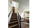 Elegant staircase with dark wood steps and black railings leading to a bright, open living area at 8426 Sluman Ct, Las Vegas, NV 89128