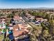 Wide aerial view showcases a neighborhood with tree-lined streets, red tile roofs, and distant mountain range at 8932 Beach Front Dr, Las Vegas, NV 89117