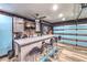 Entertainment room featuring a bar area with a large countertops, mini-fridge, brick backsplash and TV sets at 8932 Beach Front Dr, Las Vegas, NV 89117