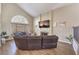 Inviting living room featuring vaulted ceilings, a large window, and a comfortable leather sectional sofa at 8932 Beach Front Dr, Las Vegas, NV 89117