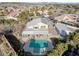 Aerial view of backyard oasis featuring a pool, covered patio, and lush landscaping in a tranquil residential setting at 9435 Westwind Rd, Las Vegas, NV 89139