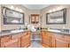 Large bathroom with double sinks, granite counters, wood cabinets, and an over-the-sink cabinet at 9435 Westwind Rd, Las Vegas, NV 89139