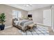 Virtual staging shows the bedroom with a modern, minimalist look, natural lighting, and a dark blue area rug at 9435 Westwind Rd, Las Vegas, NV 89139