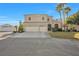 Charming two-story home featuring a spacious driveway, three-car garage, and well-manicured lawn, all under a clear blue sky at 9435 Westwind Rd, Las Vegas, NV 89139