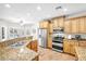 Well-lit kitchen features stainless steel appliances, granite counters, and breakfast bar at 9435 Westwind Rd, Las Vegas, NV 89139