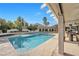 Backyard featuring a sparkling swimming pool, covered patio with seating, and lush landscaping for outdoor enjoyment at 9435 Westwind Rd, Las Vegas, NV 89139