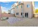 Private backyard featuring a paved patio, rock landscape, and gate to community walking trails at 10415 Scarpa St, Las Vegas, NV 89178