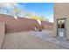 Private backyard featuring gravel landscaping, paver patio, and brick walls at 10415 Scarpa St, Las Vegas, NV 89178