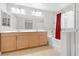 Bright bathroom featuring a double vanity, large mirror, soaking tub, and glass-enclosed shower at 10415 Scarpa St, Las Vegas, NV 89178