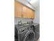 Upstairs laundry room featuring natural cabinets, modern washer, and high efficiency dryer at 10415 Scarpa St, Las Vegas, NV 89178