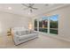 Bright bedroom with large windows, a cozy seating area, and a ceiling fan at 12160 Harris Summit Ave, Las Vegas, NV 89138