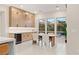 Bright dining area with wood table, white chairs, ample cabinet space, and wine fridge at 12160 Harris Summit Ave, Las Vegas, NV 89138