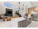 Open concept living space with kitchen island, fireplace, and staircase with modern fixtures at 12160 Harris Summit Ave, Las Vegas, NV 89138