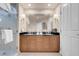 Modern bathroom with double sinks, granite counters, and framed mirror above a wood vanity at 125 E Harmon Ave # 809, Las Vegas, NV 89109