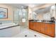Bright bathroom boasts a double vanity, bathtub, and glass-enclosed shower at 125 E Harmon Ave # 809, Las Vegas, NV 89109