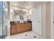 This bathroom features double sinks, granite counters, a framed mirror and a shower behind glass at 125 E Harmon Ave # 809, Las Vegas, NV 89109