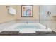 A luxurious soaking tub is featured in this bathroom with a tile surround and neutral wall colors at 125 E Harmon Ave # 809, Las Vegas, NV 89109