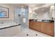 Bright bathroom with a soaking tub, walk-in shower, double sink vanity, and neutral tile flooring at 125 E Harmon Ave # 809, Las Vegas, NV 89109
