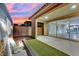 Backyard featuring a water feature, artificial turf, patio, and large sliding glass doors with views into the home at 12816 Alcores St, Las Vegas, NV 89141