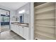 Bright bathroom with dual sinks, granite countertops, and large storage shelving at 12816 Alcores St, Las Vegas, NV 89141