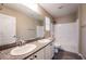 Bright bathroom featuring double vanity with granite counters, tile floors and a shower-tub combo at 12816 Alcores St, Las Vegas, NV 89141