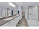 Well-lit bathroom featuring double sinks, granite countertop, sleek white cabinets, and separate walk-in shower at 12816 Alcores St, Las Vegas, NV 89141