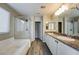 Elegant bathroom with dual sinks, a soaking tub, and a glass-enclosed shower for a spa-like experience at 12816 Alcores St, Las Vegas, NV 89141