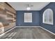 Bedroom features blue walls, laminate accent wall, and arched window at 12816 Alcores St, Las Vegas, NV 89141