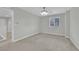 Carpeted bedroom features neutral walls, ceiling fan, and plenty of natural light from the window at 12816 Alcores St, Las Vegas, NV 89141