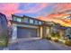 Inviting two-story home with a spacious garage, beautifully landscaped yard, and sunset backdrop at 12816 Alcores St, Las Vegas, NV 89141