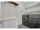 Well-lit laundry room featuring modern washer and dryer, white cabinetry and countertops, and ample shelving at 12816 Alcores St, Las Vegas, NV 89141