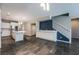 Open-concept living space with kitchen island, built-in cabinets, and stairs leading to the second floor at 12816 Alcores St, Las Vegas, NV 89141