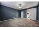 Spacious main bedroom featuring neutral carpet, dark accent wall and slider to ensuite bathroom at 12816 Alcores St, Las Vegas, NV 89141