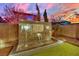 Backyard featuring a modern tiled water feature with three waterfalls, set against a colorful sunset sky at 12816 Alcores St, Las Vegas, NV 89141