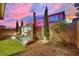 Backyard featuring a modern tiled water feature with three waterfalls, set against a colorful sunset sky at 12816 Alcores St, Las Vegas, NV 89141