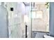 Newly tiled shower featuring a glass door, built-in seat, natural light from window, in an unfinished bathroom at 1805 Ivanhoe Way, Las Vegas, NV 89102