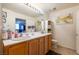 Bright bathroom features double sinks with wooden cabinets, a large mirror, and neutral decor at 19 E Agate Ave # 307, Las Vegas, NV 89123