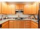 Kitchen featuring granite countertops, wood cabinets, and a gas cooktop for preparing your favorite meals at 19 E Agate Ave # 307, Las Vegas, NV 89123