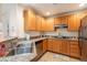 A cozy kitchen featuring granite countertops, stainless steel sink, and ample wood cabinetry at 19 E Agate Ave # 307, Las Vegas, NV 89123